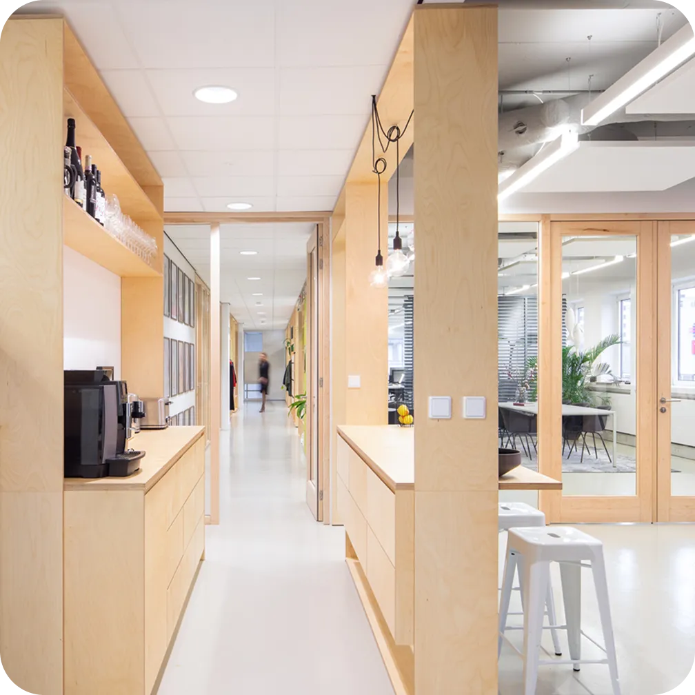 Foto van de koffiebar en gang in het kantoor van Awareways, met een medewerker die er wazig doorheen loopt.